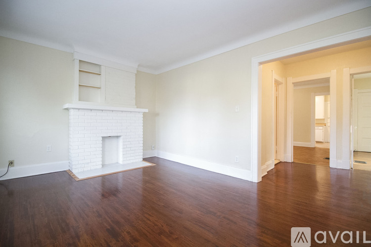 A room with a fireplace and wooden floors.