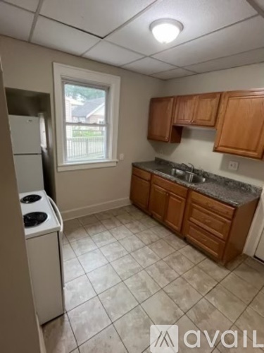 A kitchen with wooden cabinets and a white dishwasher.