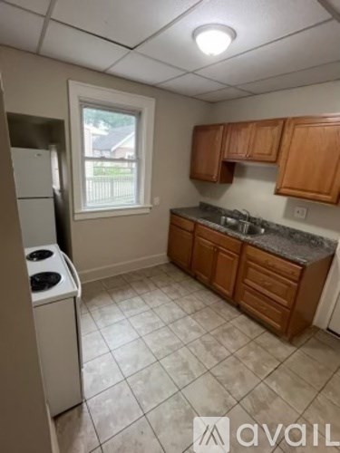 A kitchen with wooden cabinets and a white dishwasher.