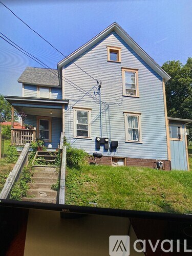 A blue house with a white roof and a small porch.