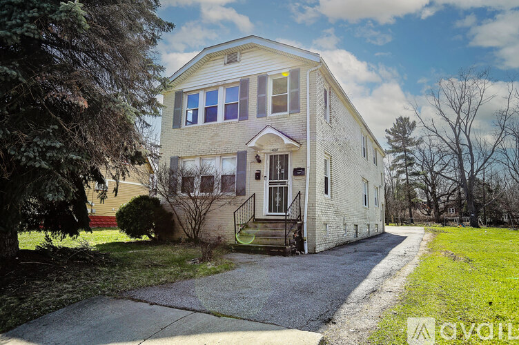 A two-story house with a front porch and a driveway.