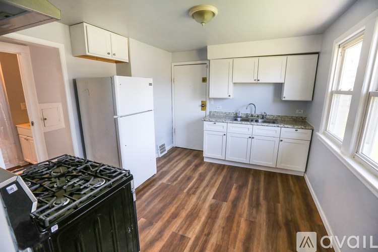 A kitchen with a black stove top oven and white cabinets.