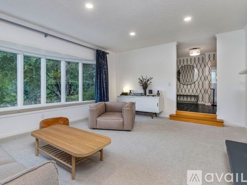 A living room with a wooden table and grey sofa.