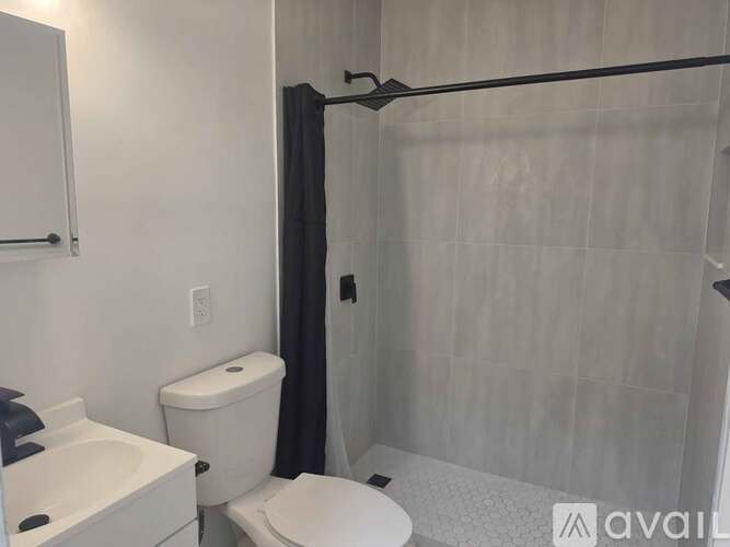 A bathroom with a toilet, sink, and shower.
