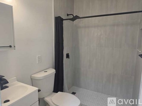 A bathroom with a toilet, sink, and shower.