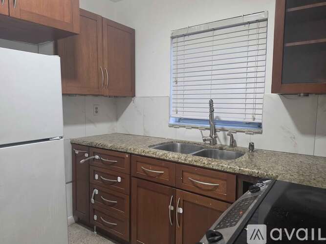 A kitchen with brown cabinets and a white refrigerator.