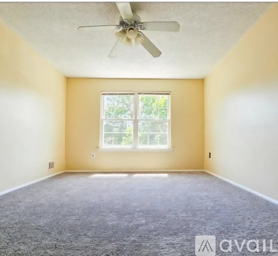 A room with a ceiling fan and a window.