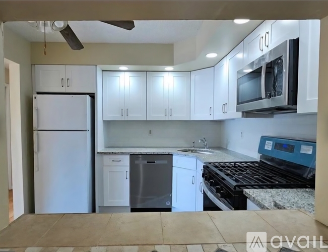 A kitchen with white cabinets and a black stove top oven.