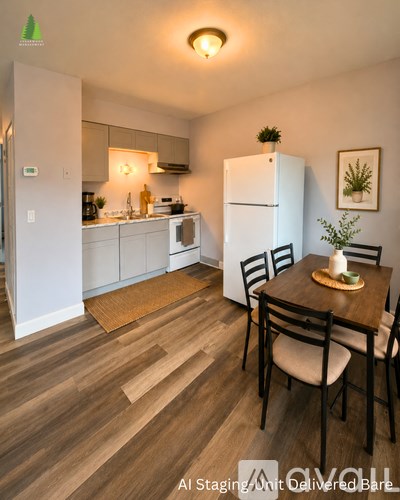 A kitchen with a table and chairs in the foreground and a refrigerator in the background.
