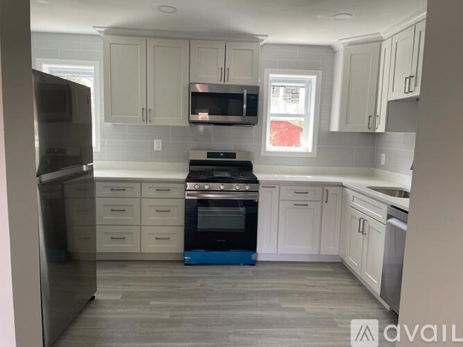 A kitchen with white cabinets and a black stove top oven.