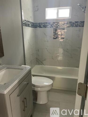 A bathroom with a toilet, sink, and shower.