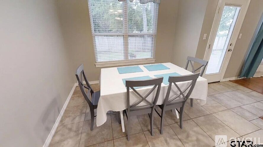 A dining room with a table and chairs.