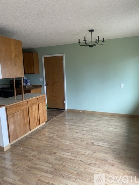 A kitchen with wooden cabinets and a chandelier.