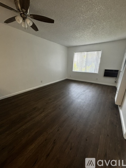 A room with wooden flooring and a ceiling fan.