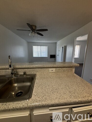 A kitchen with a sink and a fan.