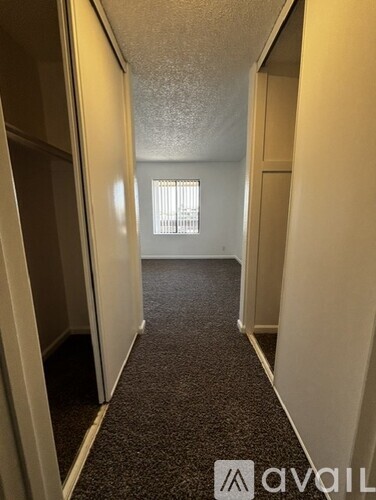 A long hallway with a carpeted floor and white walls.