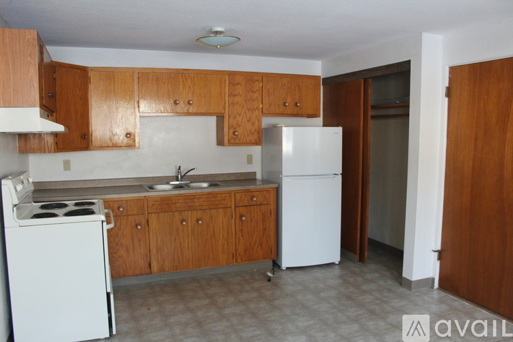 A kitchen with white appliances and wooden cabinets.