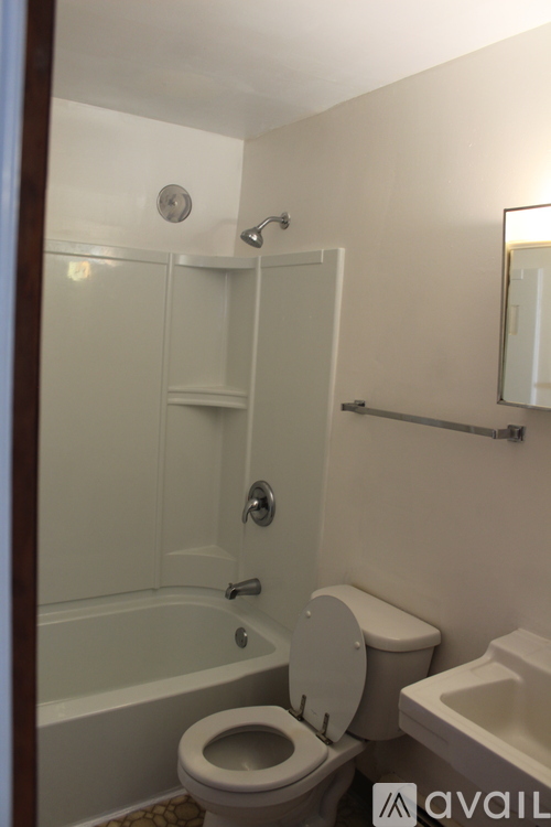 A bathroom with a toilet, sink, and shower.