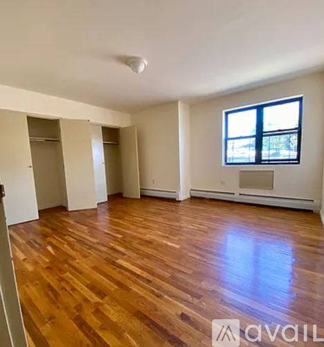 A room with wooden floors and a window with blinds.