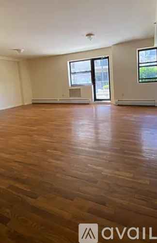A room with wooden flooring and a window.