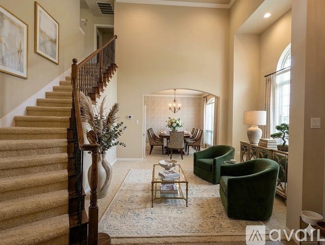 A living room with a staircase on the left and a sofa set on the right.