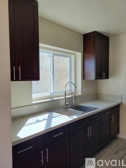 A kitchen with dark brown cabinets and a white countertop.