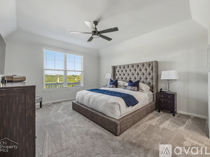A bedroom with a large bed and a ceiling fan.