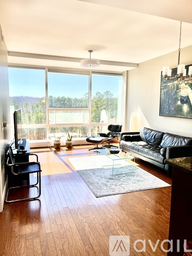A living room with a black leather couch and a glass coffee table.
