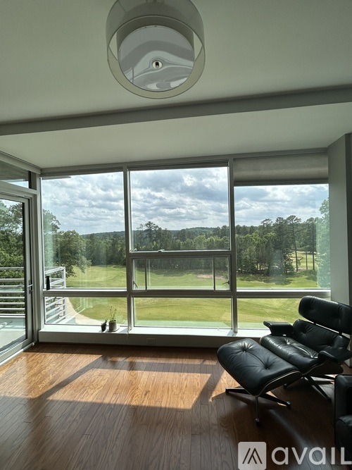 A living room with a view of a grassy field through the windows.