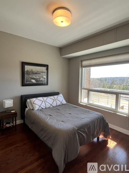 A bedroom with a large bed and a picture on the wall.