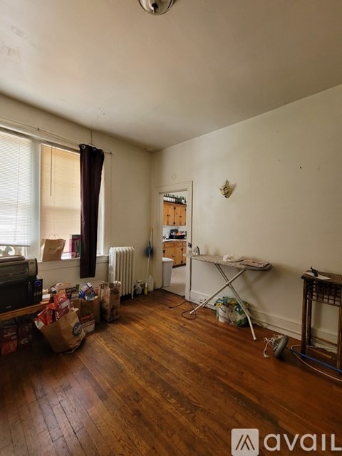 A room with wooden floors and a white wall with a small decoration on it.