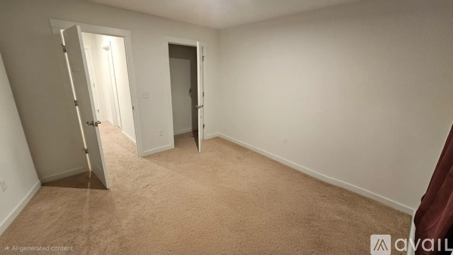 A carpeted room with a door and a wall-mounted light fixture.