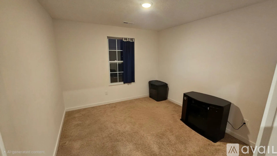 A living room with a black TV and a window with a blue curtain.