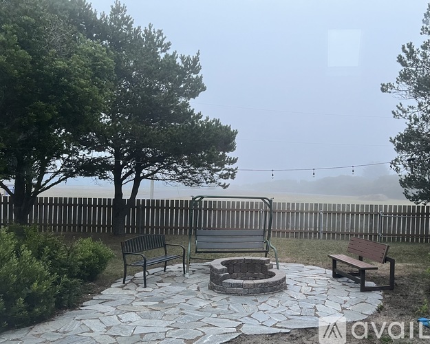 A park bench sits in the middle of a stone patio.