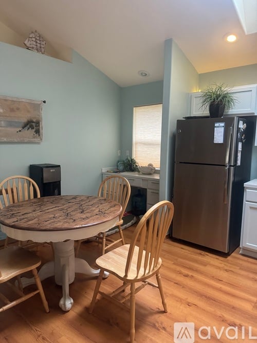 A kitchen with a table and chairs.