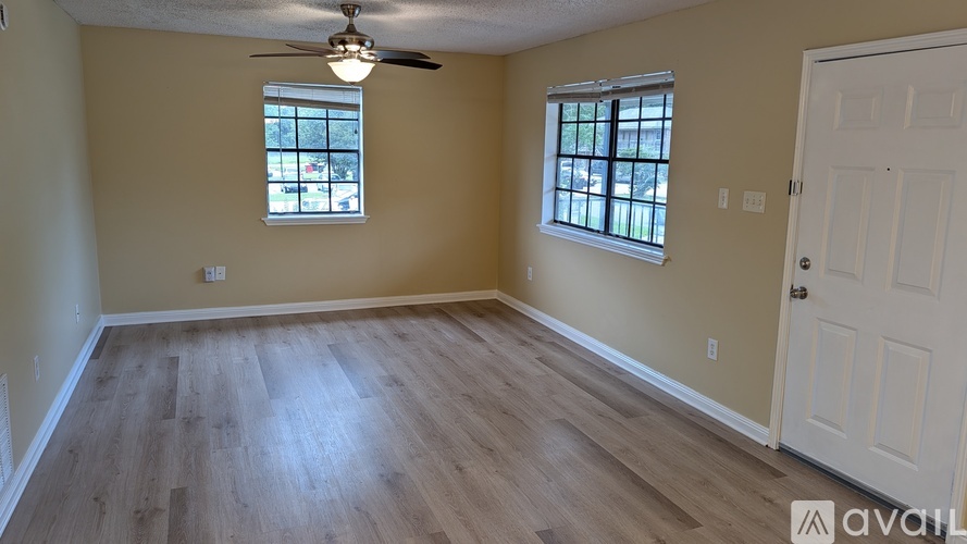A room with wooden flooring and a ceiling fan.