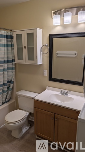A bathroom with a toilet, sink, and medicine cabinet.