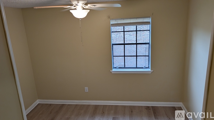 A room with a window and a ceiling fan.