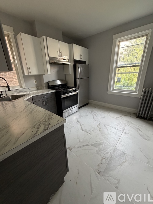 A kitchen with a marble counter top and a window.