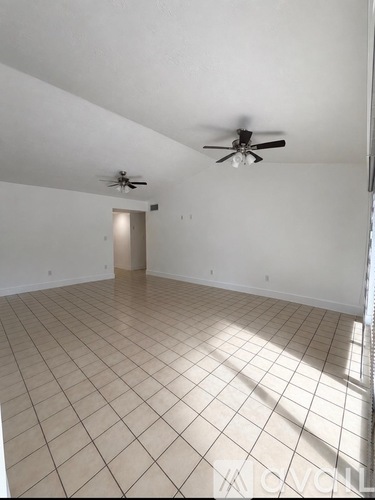 A room with a ceiling fan and tiled floor.