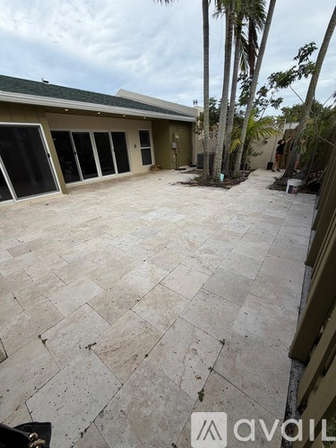 A patio area with a tiled floor and a building in the background.