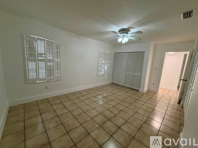 A spacious room with a ceiling fan and tiled flooring.