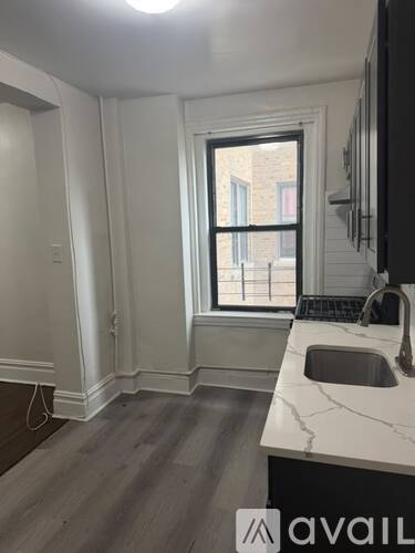 A kitchen with a marble countertop and a window.