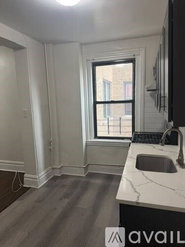 A kitchen with a marble countertop and a window.