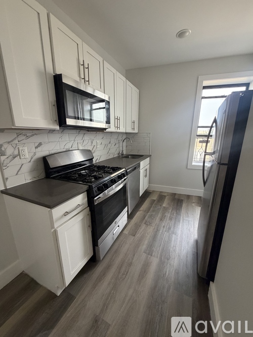 A kitchen with white cabinets and a black stove top oven.