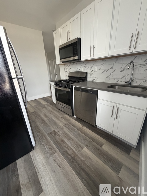 A kitchen with a black fridge, stove, and microwave.