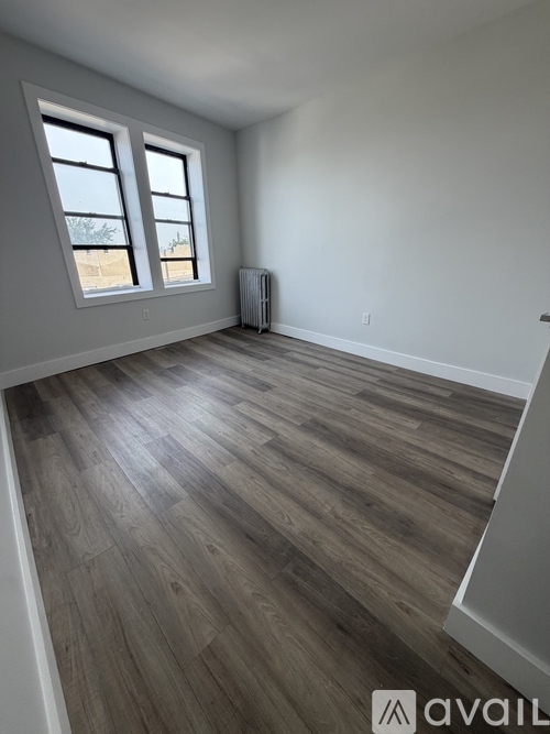 A room with wooden flooring and a window.