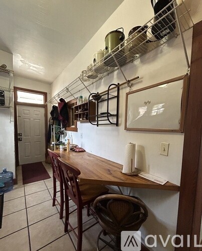 A kitchen with a table and chairs.