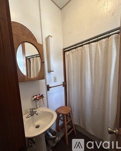 A bathroom with a sink, mirror, and shower.