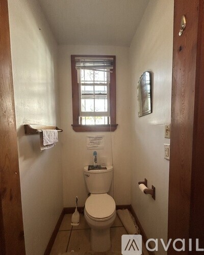 A small bathroom with a toilet and a window.